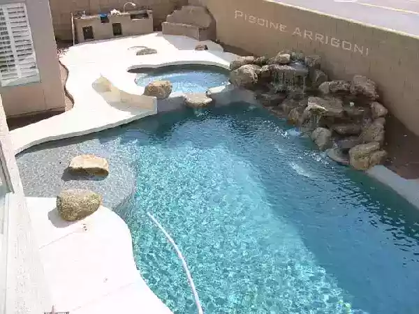 Piscina con idromassaggio, cascate e rocce finte.